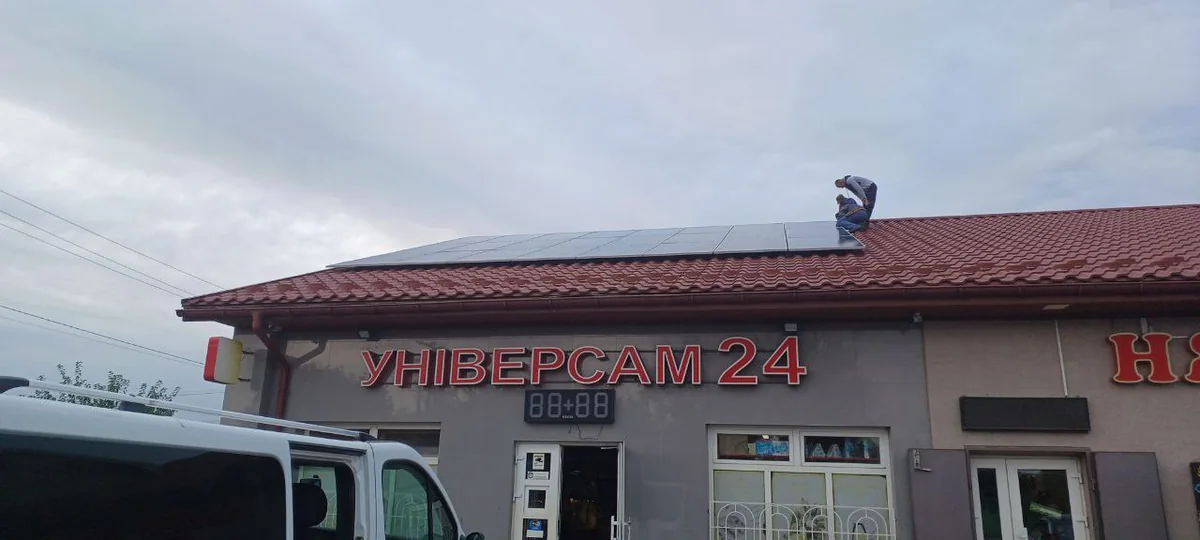 Будівля магазину із сонячними панелями на даху, ширший план