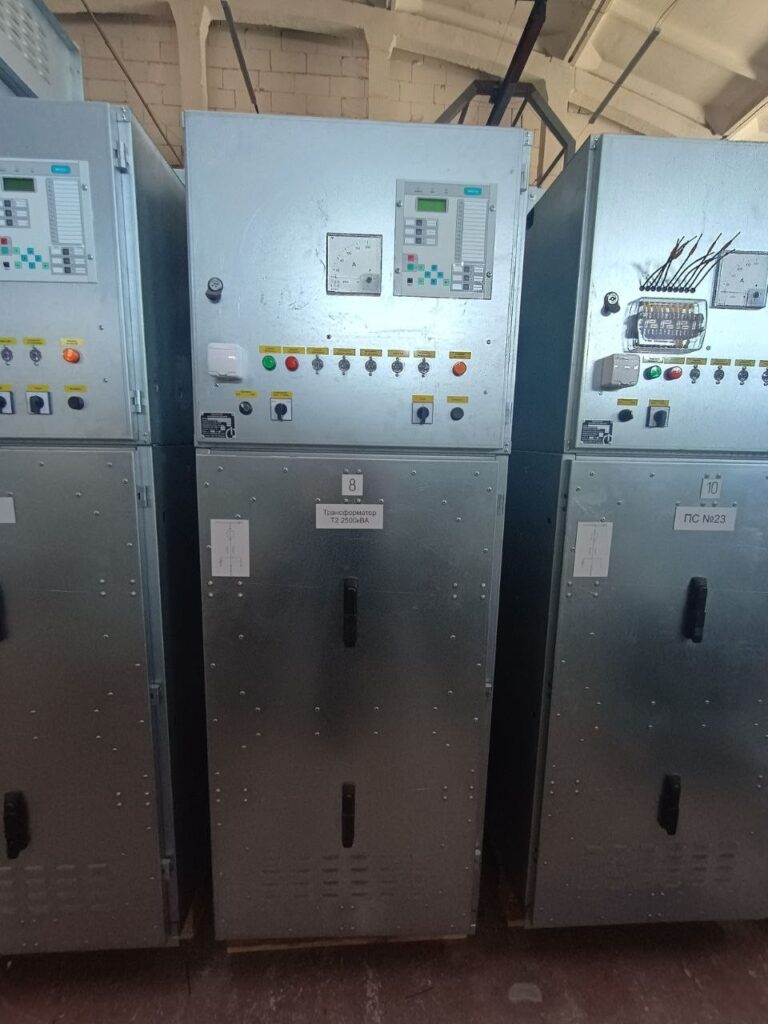 Row of switchgear cabinets with microprocessor protection terminals in production workshop