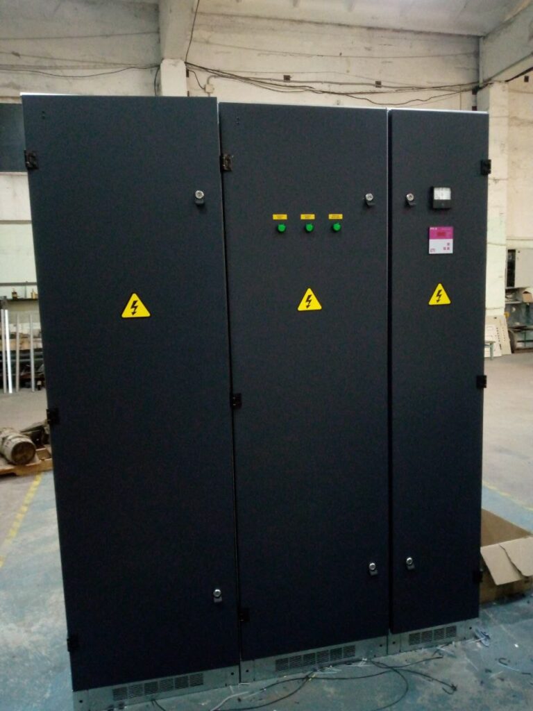 Finished dark-grey floor-standing switchboard cabinets at the production workshop