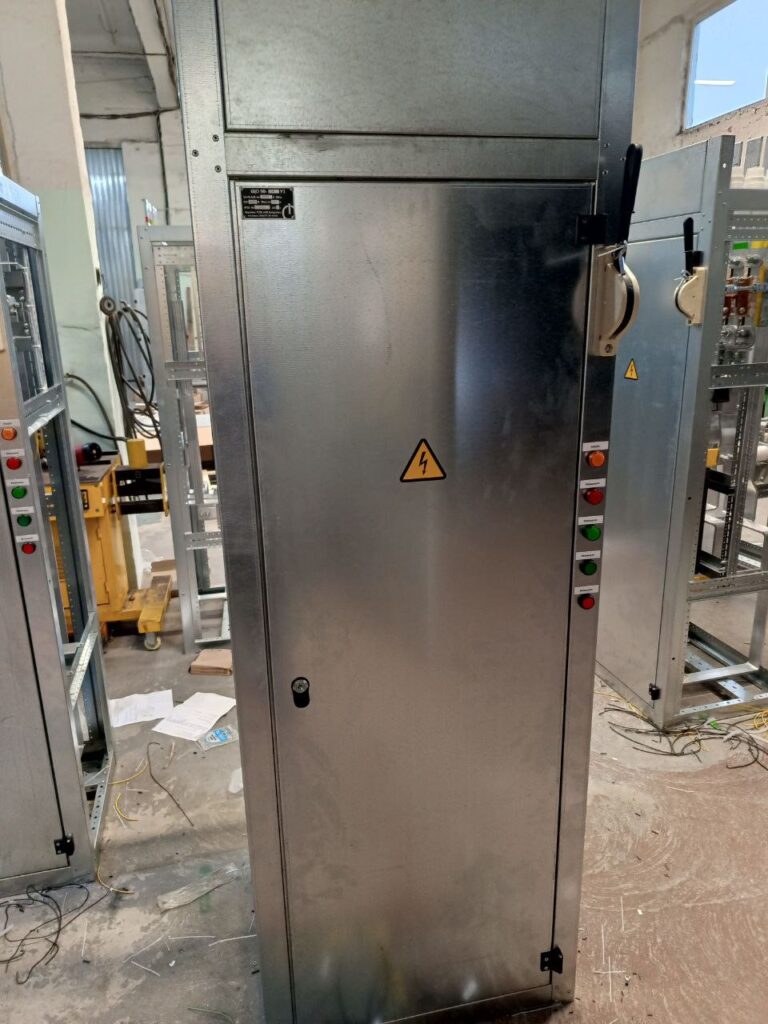 Floor-standing electrical cabinet with nameplate and control push buttons in workshop
