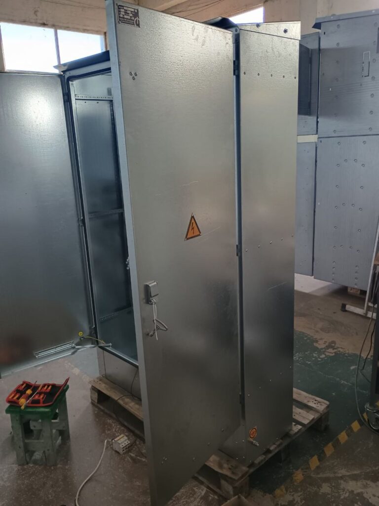Galvanized floor-standing switchgear cabinet enclosure with open door in the workshop