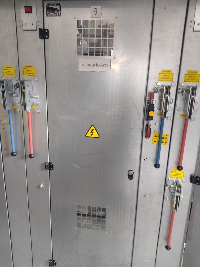 Bus section switch cubicle in switchgear lineup with manual operating drives