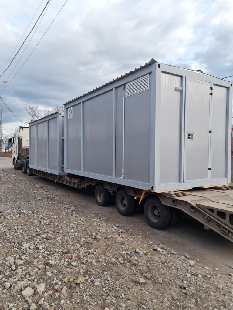 Two prefabricated modular buildings being transported on a low-bed trailer