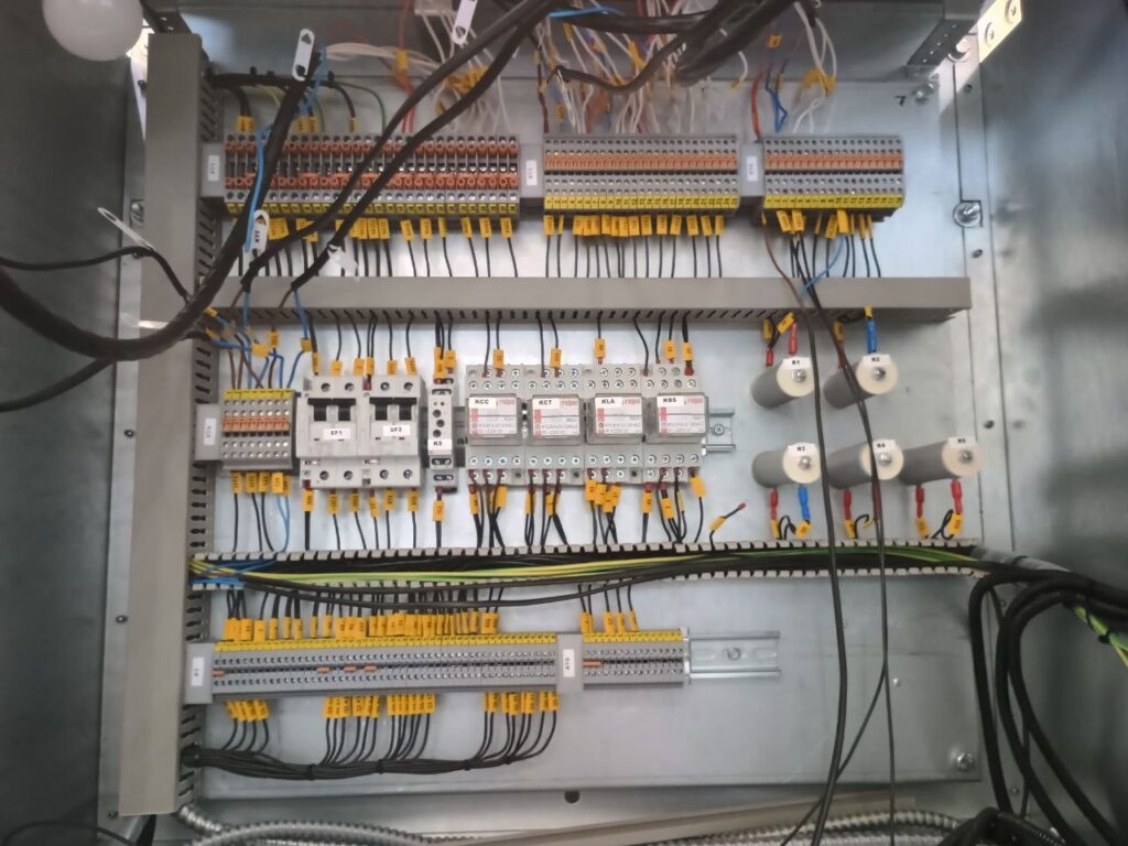 Automation cabinet wiring: terminal block rows, auxiliary relays and resistors with circuit markings