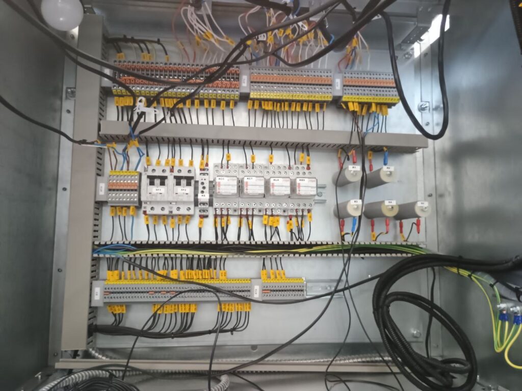 Inside an automation cabinet: terminal blocks, relays, resistors and wire harnesses